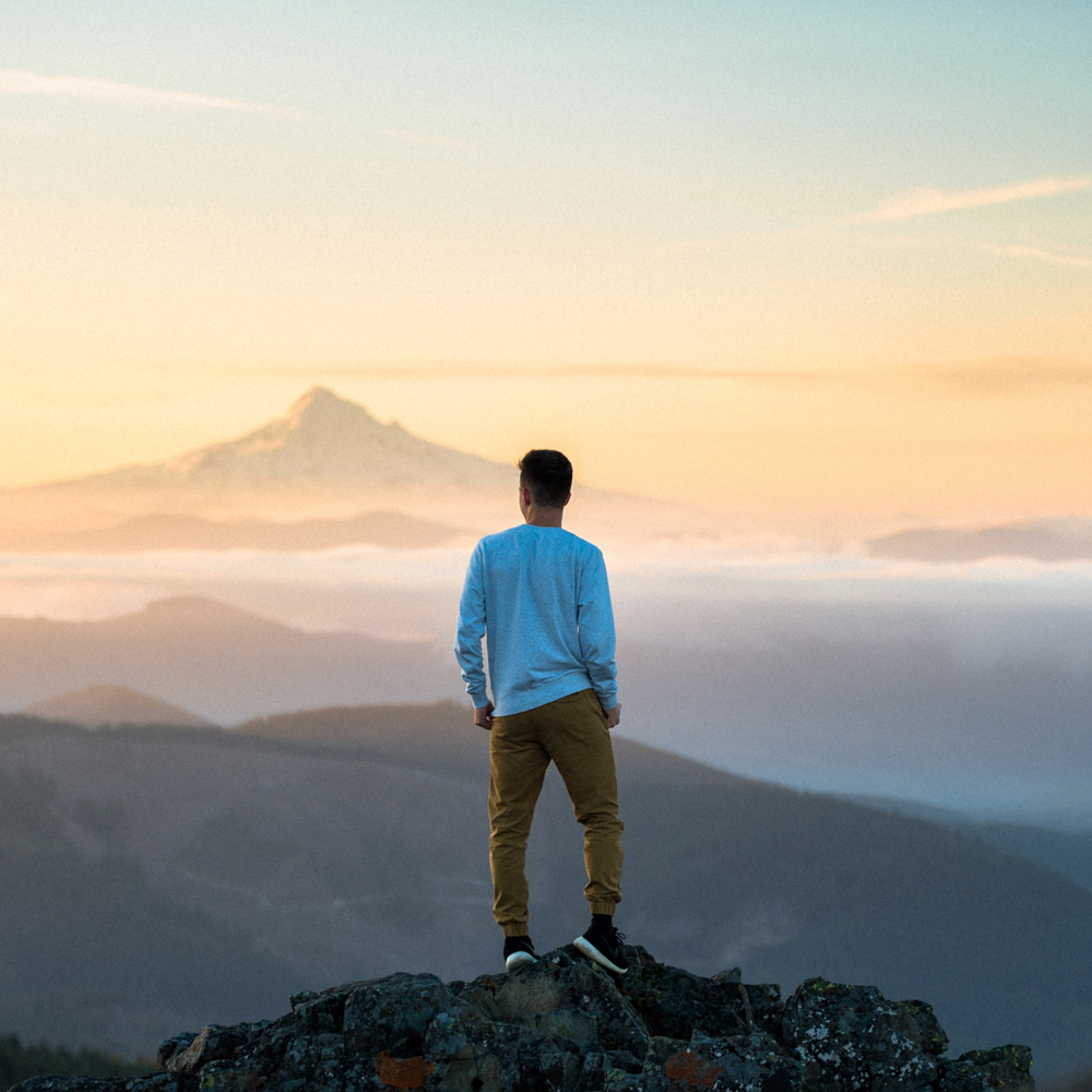man on mountain top Photo by tim bogdanov on Unsplash